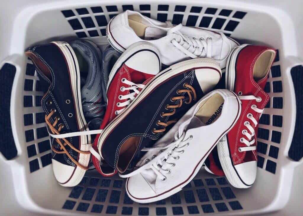 White laundry basket full of sneakers.