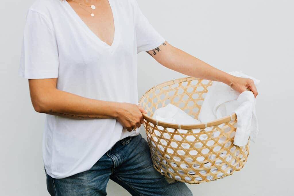 plastic-free laundry: woman holding laundry basket