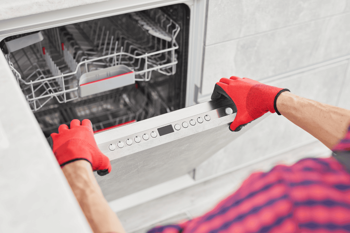 person with gloved hands opening dishwasher door
